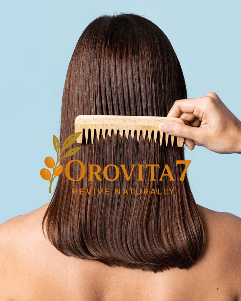 The back of a person with long, straight, shiny brown hair being combed with a wide-tooth wooden comb. The OROVITA7 logo is centered over the hair.