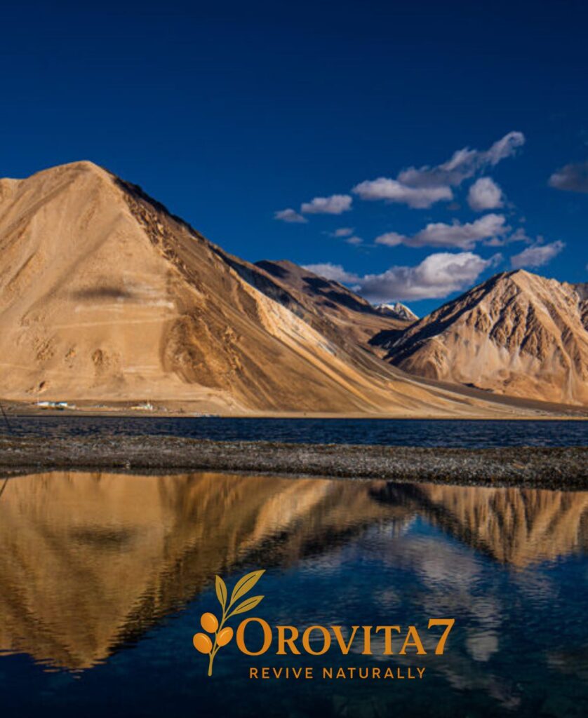 A crystal-clear reflection of sun-drenched Himalayan mountains in a still pool of water at dusk, with the OroVita7 logo positioned at the bottom center.