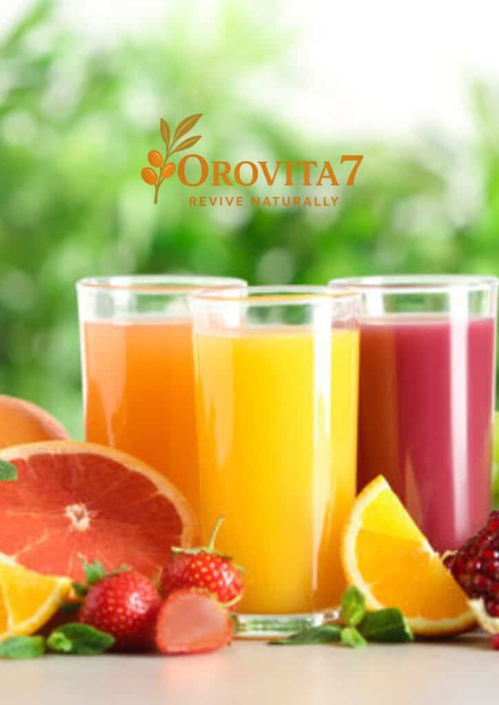 Three glasses of colorful fruit juices—orange, yellow, and pink—placed behind fresh grapefruit and orange slices with the OroVita7 Revive Naturally logo centered above.