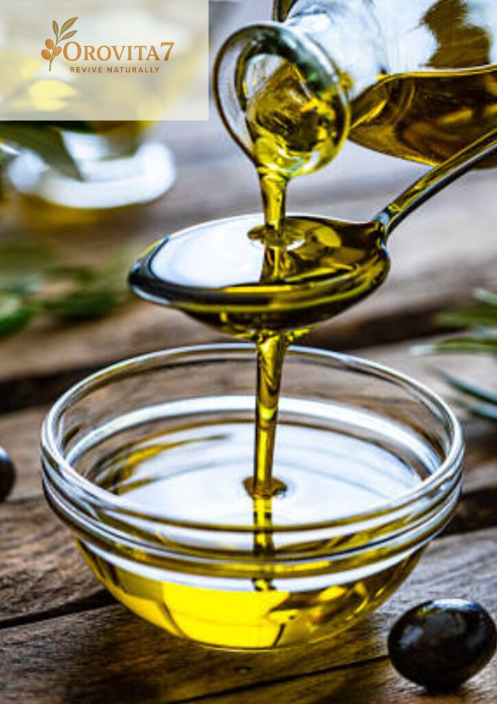 Golden olive oil being poured from a glass bottle onto a spoon and into a clear glass bowl, featuring the Orovita7 logo.