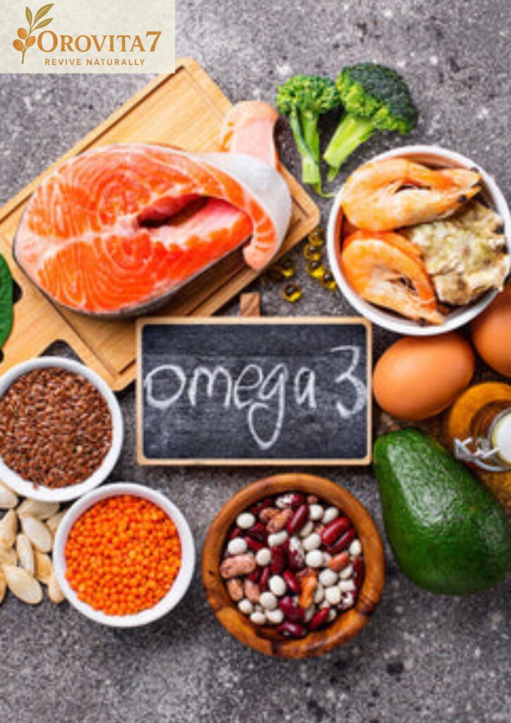 A flat-lay composition of various Omega-3 rich foods including salmon, shrimp, eggs, flax seeds, lentils, beans, avocado, and broccoli. A small chalkboard in the center reads "omega 3" in white chalk, with the OroVita7 logo placed in the top-left corner.