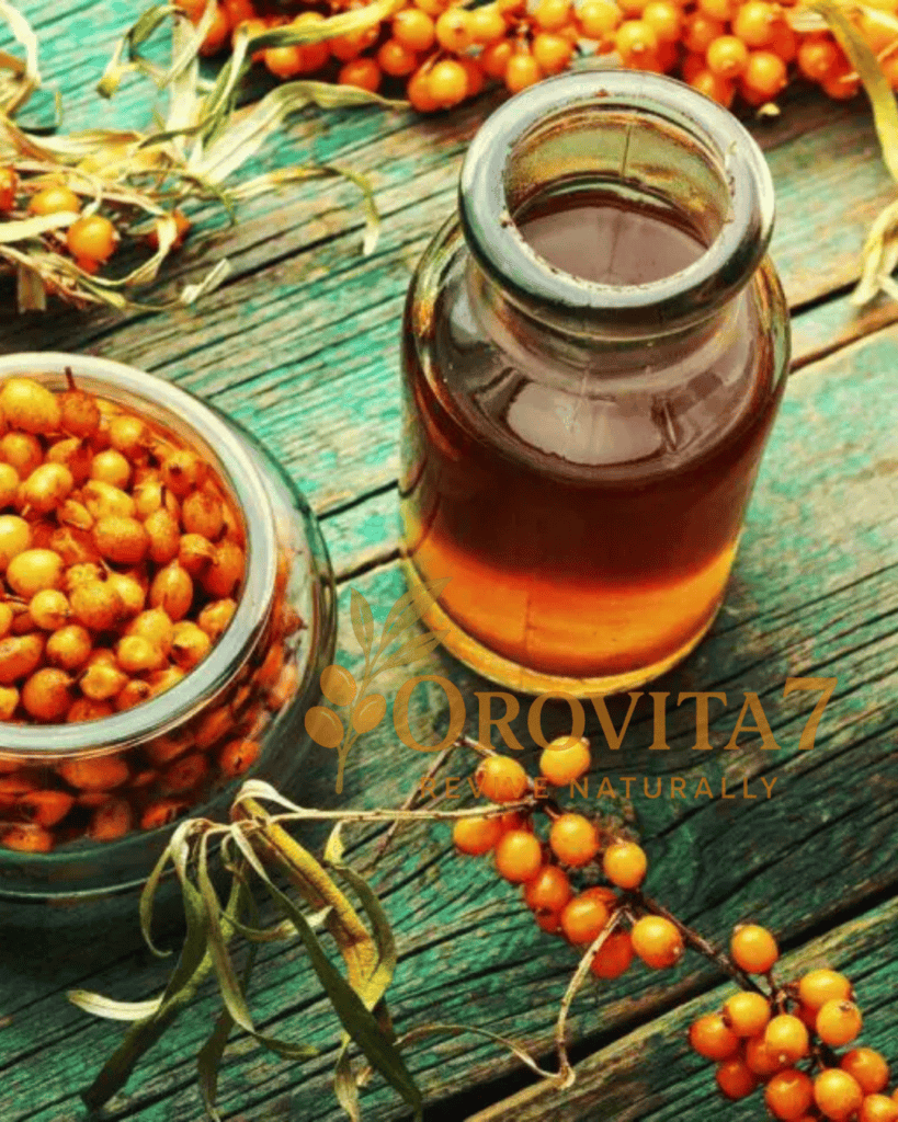 A glass bottle containing golden sea buckthorn oil next to a jar of fresh berries on a green-tinted wooden table, branded with OroVita7 Revive Naturally.
