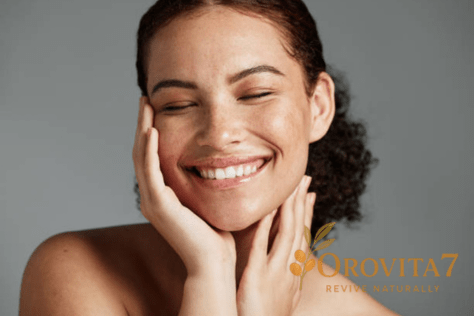 Close-up of a smiling woman with freckles and eyes closed, highlighting smooth and well-hydrated skin texture.