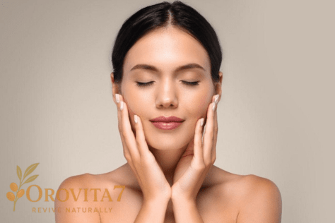 A serene woman with her eyes closed holding her face, representing a calm and effective skin care routine with OroVita7.