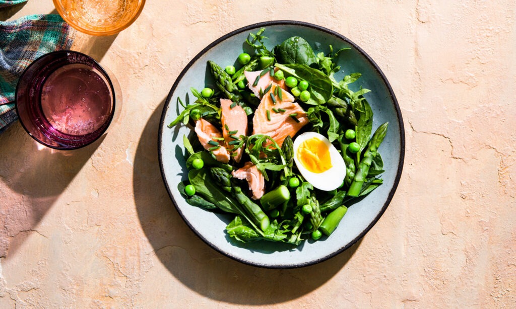 A vibrant collage of nutrient-dense foods high in Vitamin B12. It features images of salmon, red meat, eggs, milk, and cheese, emphasizing that B12 is primarily found in animal-based products.