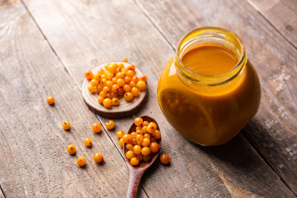 Sea Buckthorn Oil Side Effects concept with sea buckthorn berries and herbal oil bottle